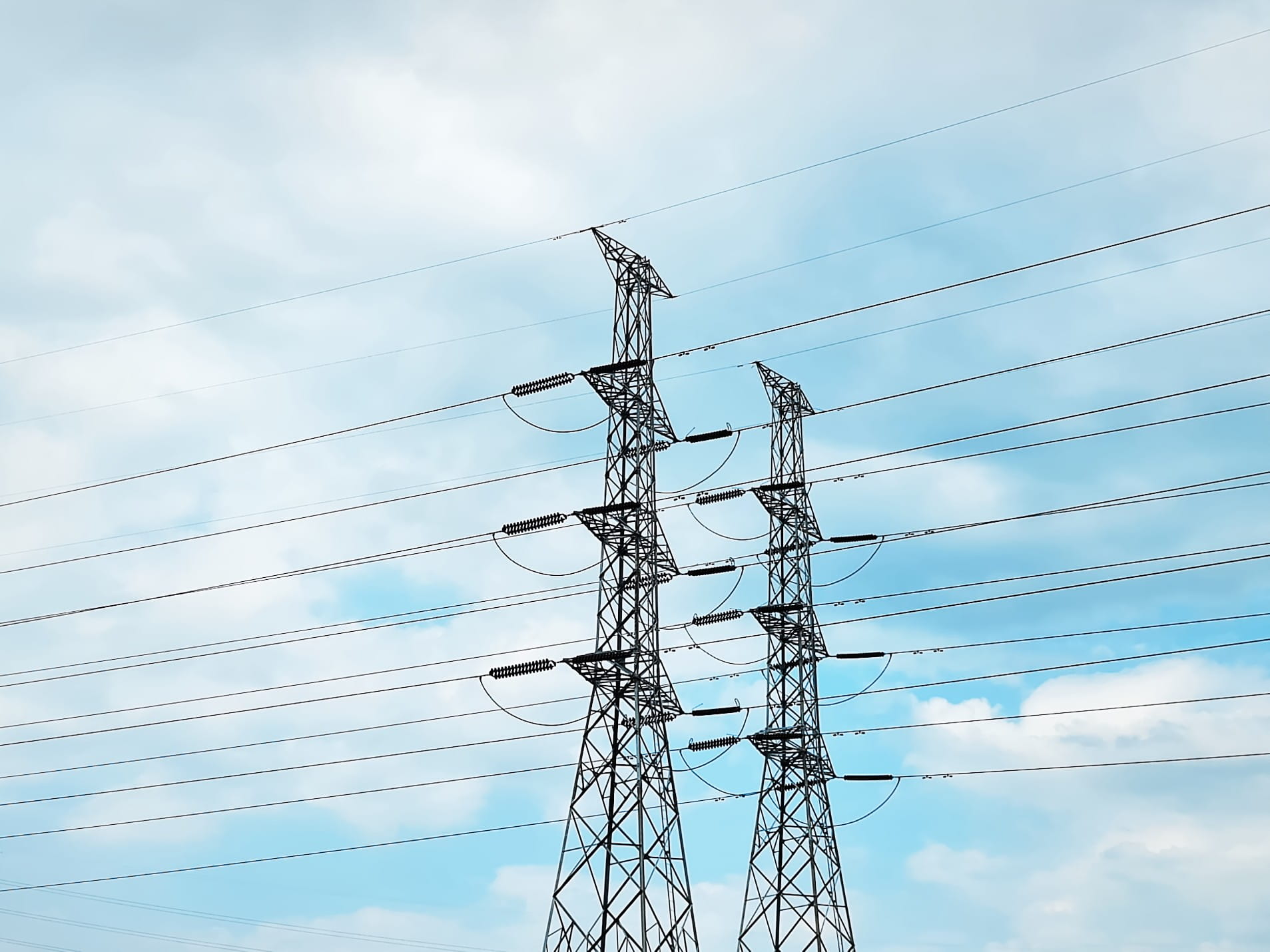 low angle view of high voltage power transmission towers