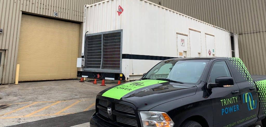 Trinity truck in front of a large generator.,